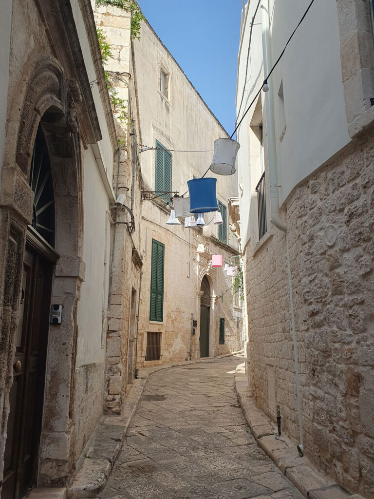 Empty lane with lampshades overhead, Conversano