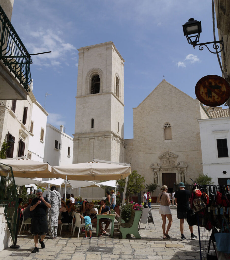 Polignano a Mare: the Chiesa Madre and restaurant tables in Piazza Vittorio Emanuele